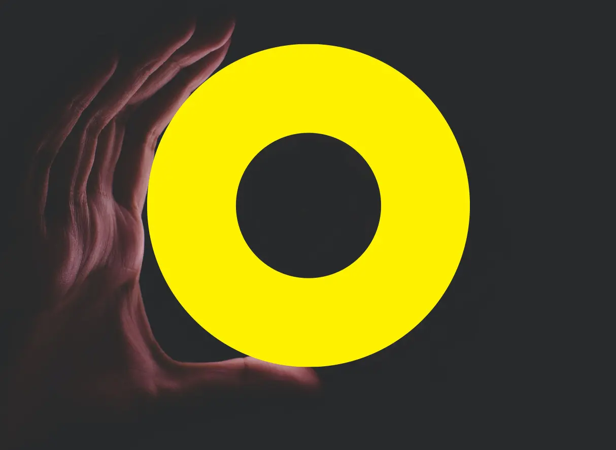 a hand in the dark, holding an illuminated yellow circle